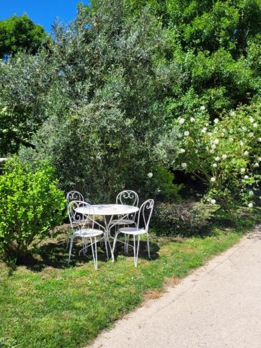 a table and two chairs sitting in the grass at Maison à la campagne proche de La Rochelle in Sainte-Soulle