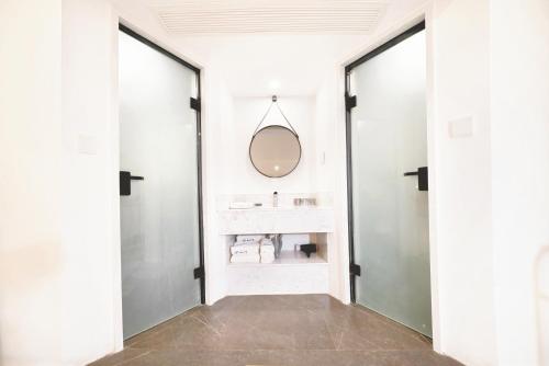 a bathroom with two glass doors and a sink at 平潭游记猫头墘古村落 in Pingtan