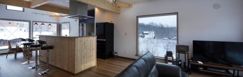 a living room with a television and a large window at Niseko East Mountain in Niseko
