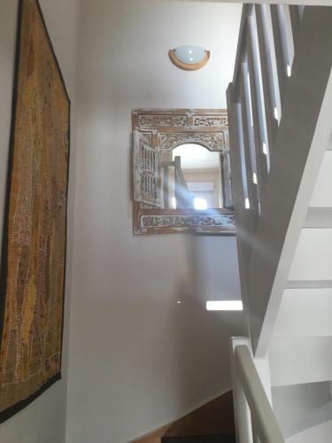 un miroir sur un mur à côté d'un escalier dans l'établissement À Royan chez Antoine, à Royan