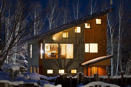 a home lit up at night in the snow at Niseko East Mountain in Niseko
