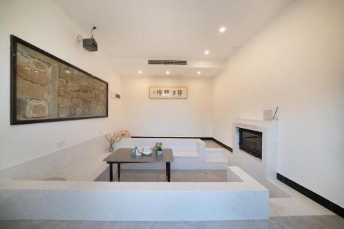 a living room with a table and a fireplace at 平潭游记猫头墘古村落 in Pingtan