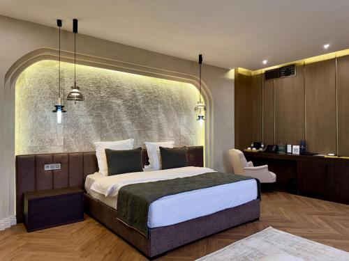 Un dormitorio con una cama grande y un escritorio. en Donatello Boutique Hotel, en Almaty
