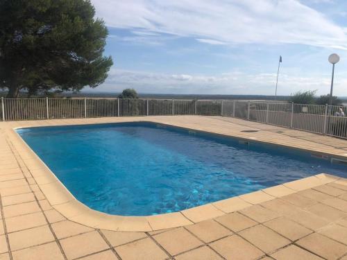 une piscine avec de l'eau bleue dans une cour dans l'établissement Mas de Perimont 28, à Fleury