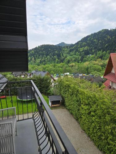 a balcony with benches and a view of the mountains at Kamila in Szczawnica