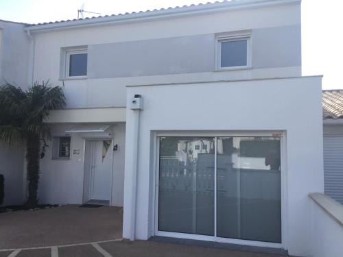 une maison blanche avec une porte coulissante en verre dans l'établissement À Royan chez Antoine, à Royan