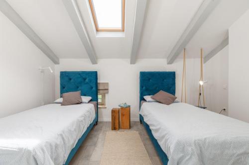 two beds in a room with white walls at Villa Jona in Žužići