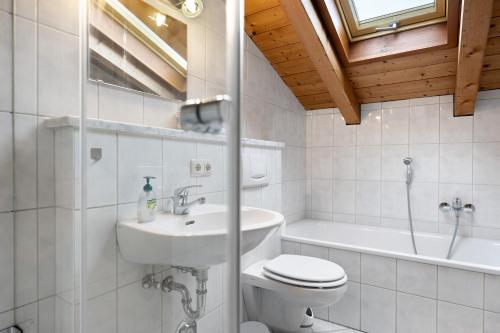 a bathroom with a toilet and a sink and a tub at Kramer in Garmisch-Partenkirchen