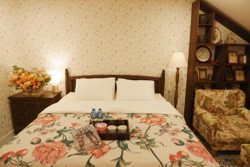 - une chambre avec un lit doté d'un couvre-lit floral et d'une chaise dans l'établissement The Rustic Home - Room 2, à Hô-Chi-Minh-Ville