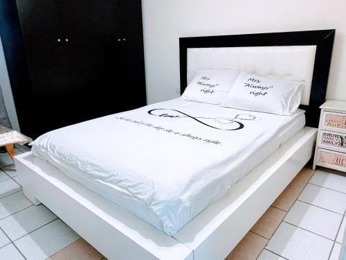 a bed with white sheets and pillows on it at Apartments Lev Eilat 2 in Mashabbe Sade