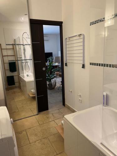 une salle de bain avec une baignoire, un lavabo et un miroir dans l'établissement Le Mas d'Or, à Saint-Rémy-de-Provence