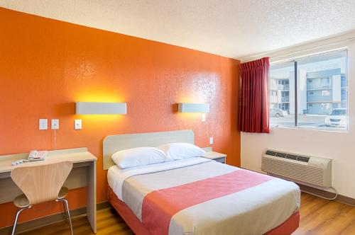 a bedroom with a bed and a desk and a window at Motel 6- Denver, CO Downtown in Denver