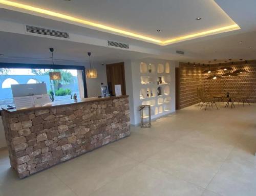 una hall con bancone e muro di pietra di Hotel Club Sunway Punta Prima a Es Pujols