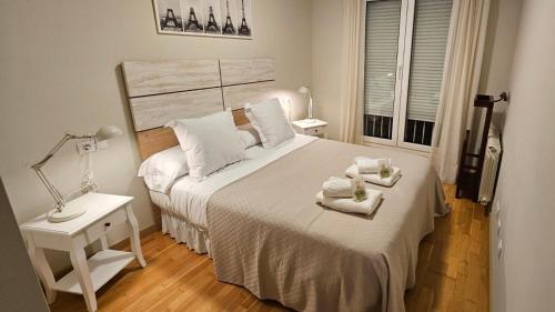 a bedroom with a large bed with towels on it at Apartamento Turístico Nanielles Sella Playa - VUT 3050AS in Ribadesella