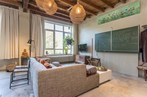 a living room with a couch and a chalkboard on the wall at Bed en Breakfast Reijmerstok in Reijmerstok