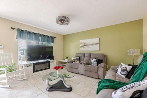 a living room with a couch and a tv at Tampa Stadium Vacation Rental in Tampa