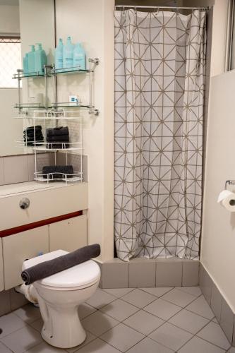 a bathroom with a toilet and a shower curtain at Cottesloe Beach View Apartments No.8 in Perth
