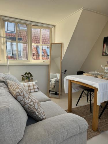 a living room with a couch and a table at tiny beach house noordwijk in Noordwijk aan Zee