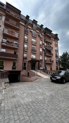 a large building with a car parked in front of it at Modern Retreat in Skopje