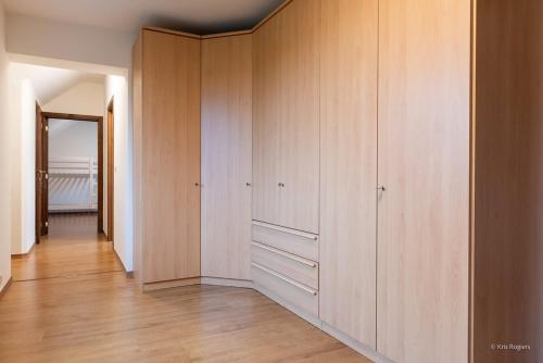 a room with wooden cabinets and a hallway at 14 beds, 20p, 2 bath-, 1 livingroom in Houthalen-Helchteren