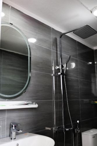 a bathroom with a shower with a mirror and a sink at Khách sạn Phan văn 1 in Danang