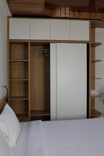 a bedroom with a white bed and a closet at Khách sạn Phan văn 1 in Danang