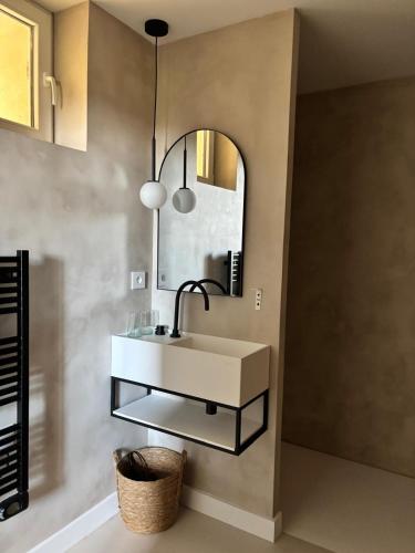 a bathroom with a sink and a mirror at La Maison des Jardins in Gigondas