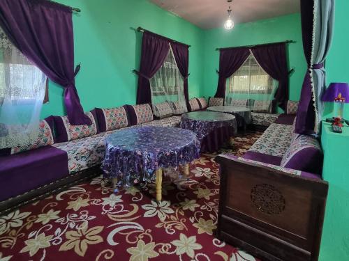 a living room with purple furniture and a table at Auberge La belle vue in Daher
