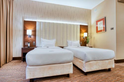 a hotel room with two beds and a desk at Copernicus Toruń Hotel in Toruń
