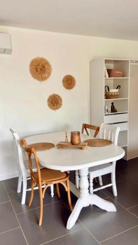 - une table et des chaises blanches dans la salle à manger dans l'établissement Appartement Malibu, à Lapalme