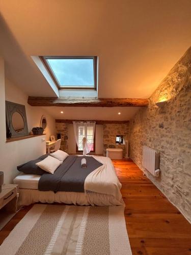 une chambre avec un grand lit avec une lucarne dans l'établissement Maison de charme à Bélesta, à Bélesta