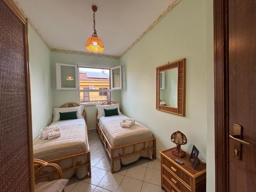 Un dormitorio con dos camas y un espejo. en Aspra Mare House, en Ficarazzi