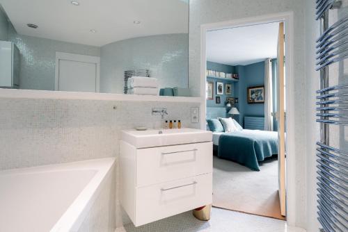 une salle de bain avec un lavabo, une baignoire et un lit dans l'établissement Veeve - Artful Escape, à Paris