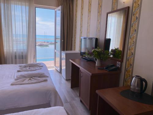 Una habitación de hotel con una cama y vista al océano. en Lotos Hotel, en Balchik