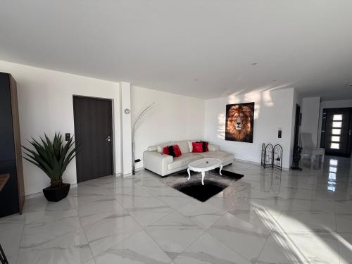 ein weißes Wohnzimmer mit einer Couch und einem Tisch in der Unterkunft Villa Princesse neuve & grand standing ! in Valmont