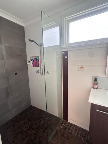 a shower with a glass door in a bathroom at Comfortable and Spacious Queen Room - SW2 in Wentworthville