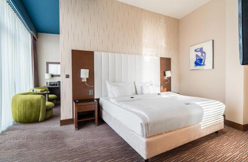 a large white bed in a hotel room at Copernicus Toruń Hotel in Toruń