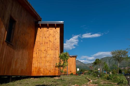 two wooden buildings sitting next to each other at Mesopotam Agrotourism Resort in Sarandë