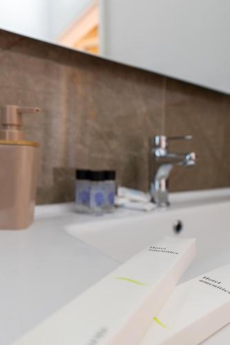 a bathroom sink with a faucet and a mirror at Mesopotam Agrotourism Resort in Sarandë