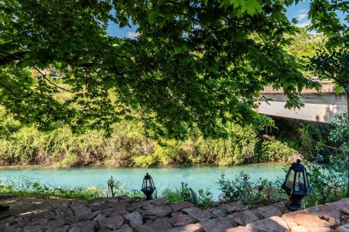 a bridge over a river with two lights in front at Mesopotam Agrotourism Resort in Sarandë