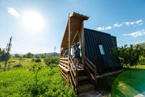 a group of people standing on the porch of a tiny house at Mesopotam Agrotourism Resort in Sarandë