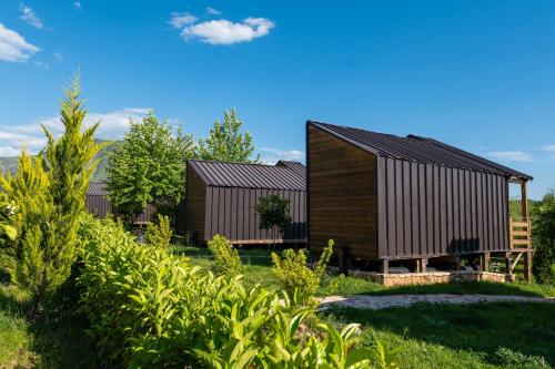 a wooden house with a black roof at Mesopotam Agrotourism Resort in Sarandë