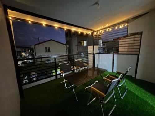 a balcony with chairs and a table and lights at D&D Transient House in Sampong