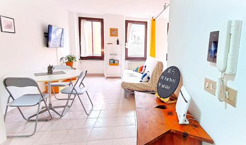 a living room with a table and chairs and a kitchen at NEL CUORE DEL FESTiVAL -CENTRALiSSiMO&STRATEGiCO- in Trento