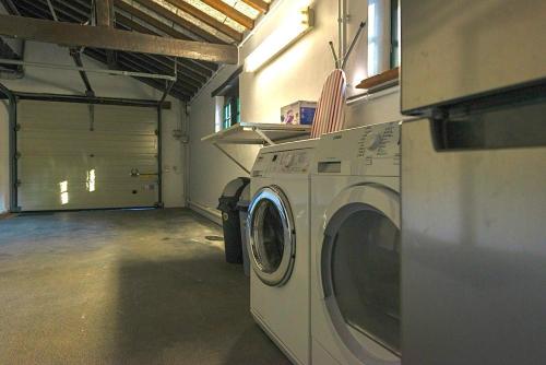 a washer and dryer in a garage at Luxe Vacation Villa with swimming pool, 5 bedrooms in Houthalen-Helchteren