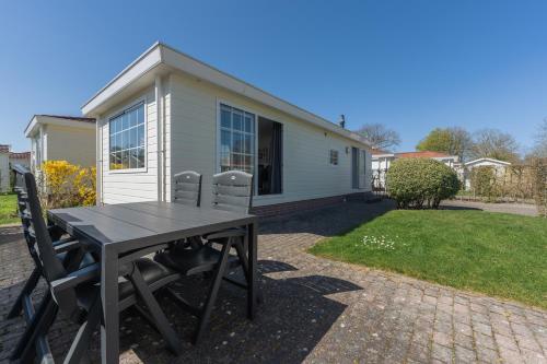 a picnic table in front of a tiny house at Holiday Park Dennenbos in Oostkapelle