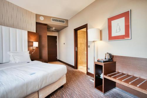 a hotel room with a large bed and a table at Copernicus Toruń Hotel in Toruń