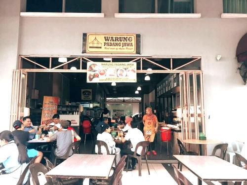 a group of people sitting at tables in a restaurant at Riverson SOHO Kota Kinabalu in Kota Kinabalu