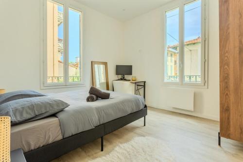 une chambre avec un lit et deux fenêtres dans l'établissement Nice Magnan, Appartement proches plage et tramway, à Nice