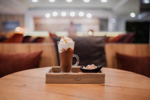 a cup of coffee sitting on a wooden table at Hotel Matija Gubec in Stubicke Toplice